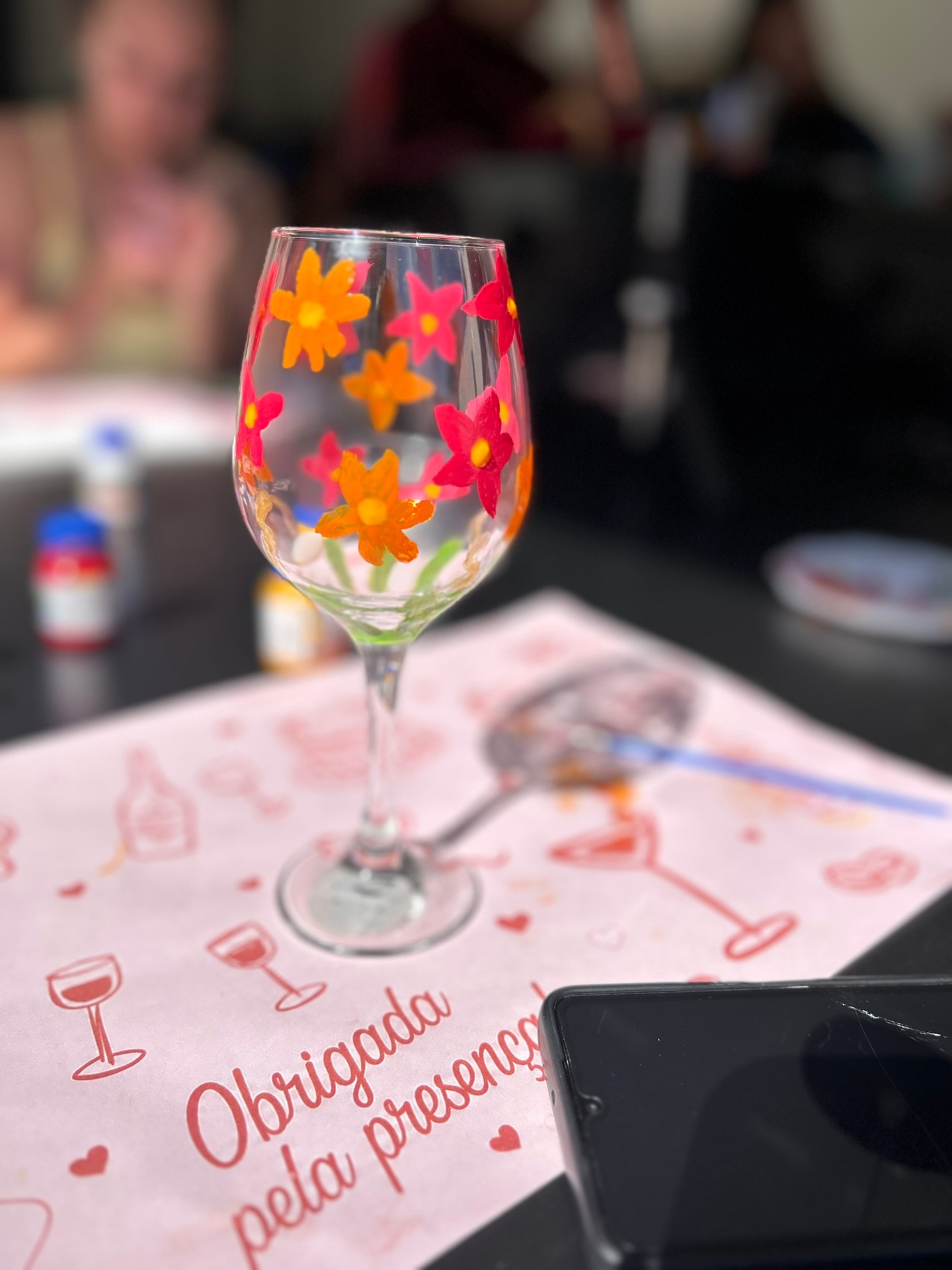 Taça de vinho pintada à mão com flores vermelhas e laranjas