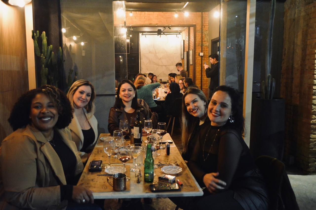 Grupo de amigas reunidas à mesa em noite especial