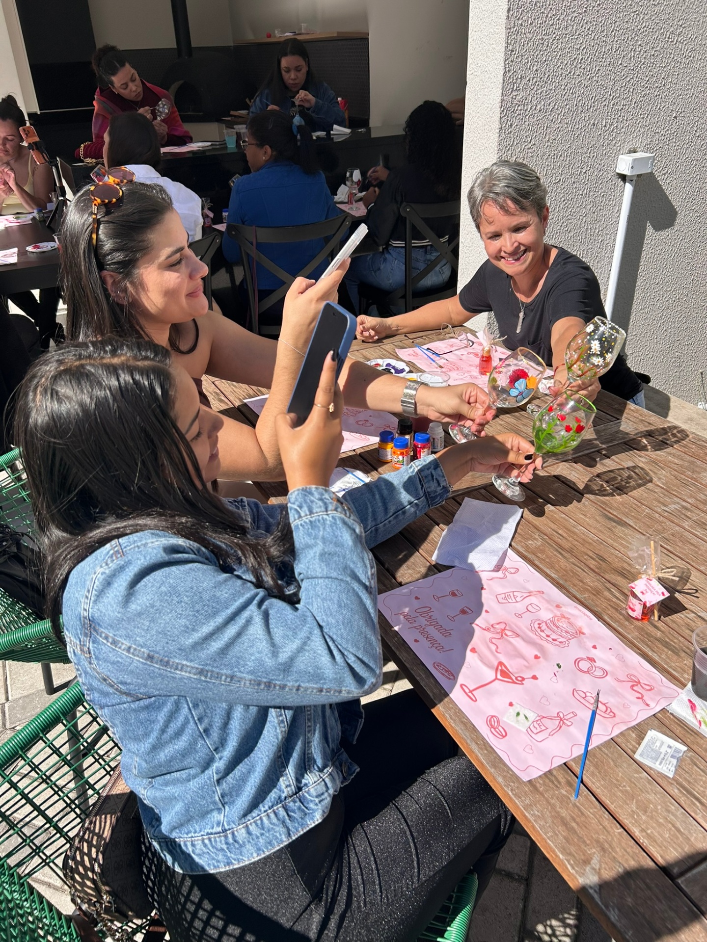 Amigas registrando suas taças pintadas em momento descontraído