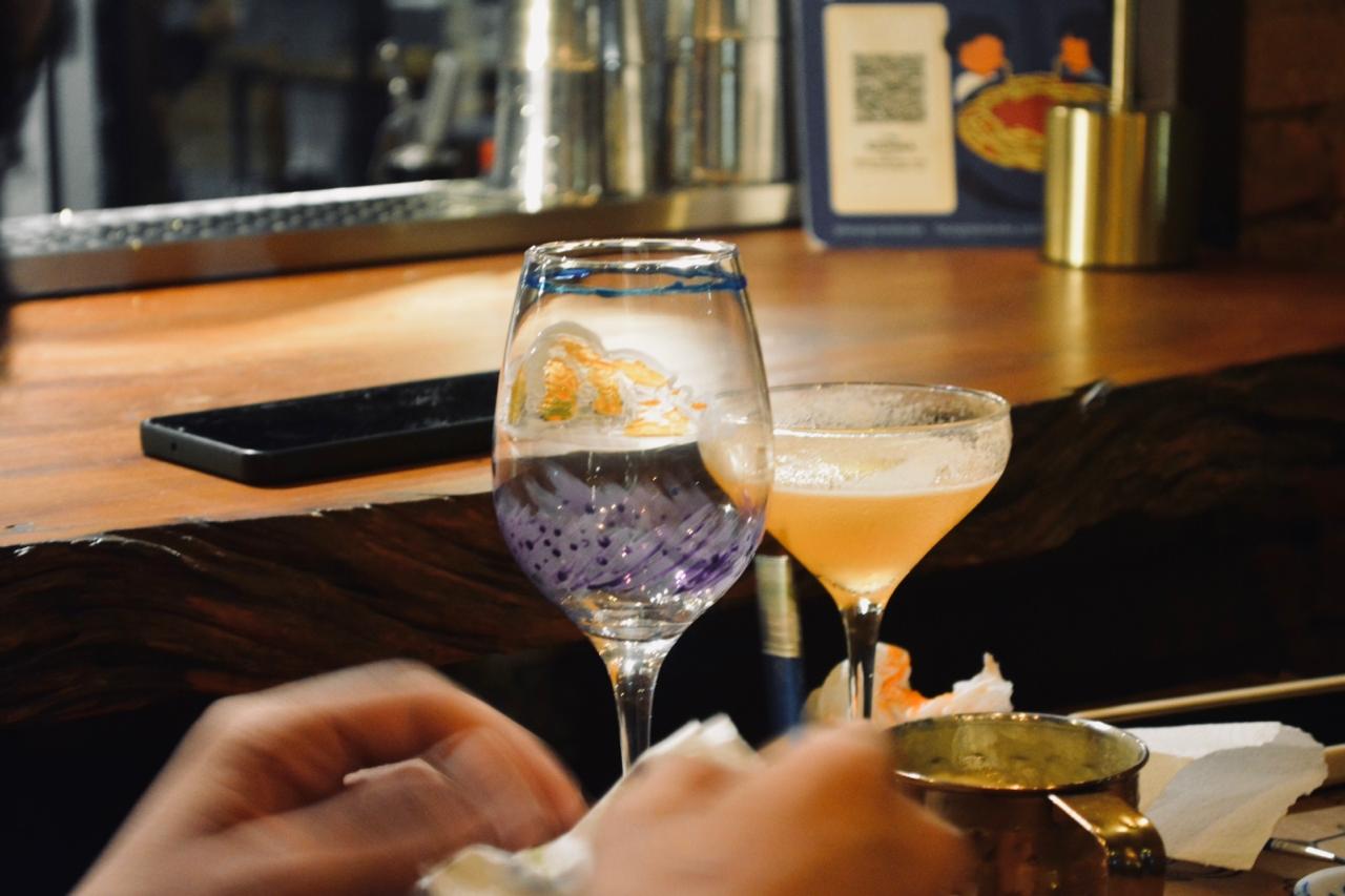 Taça artesanal com pintura em roxo e dourado sobre o balcão