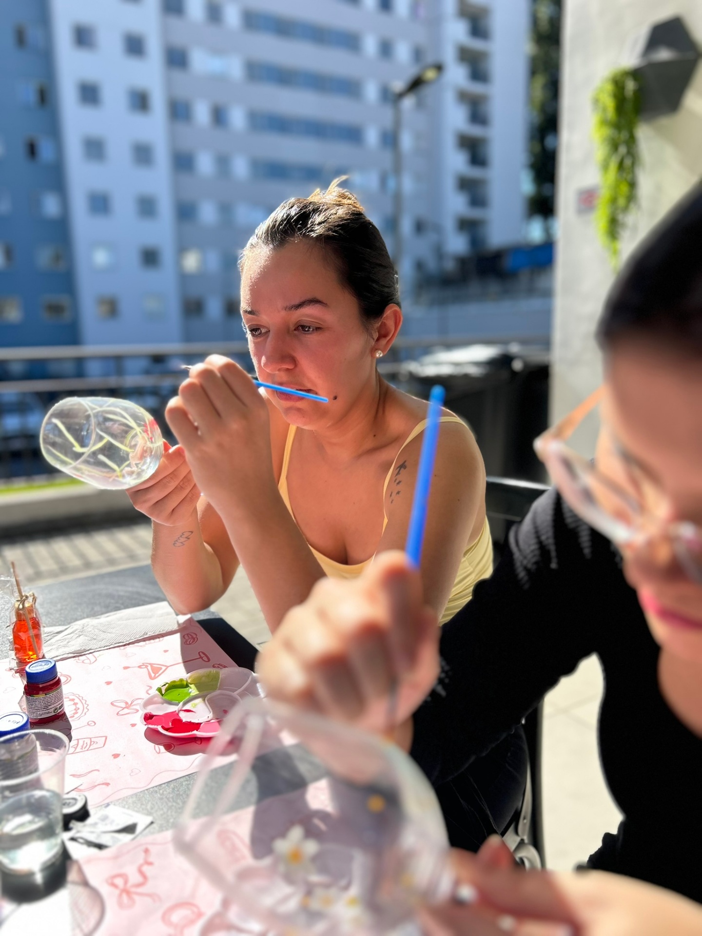 Mulher concentrada pintando taça de vinho ao ar livre