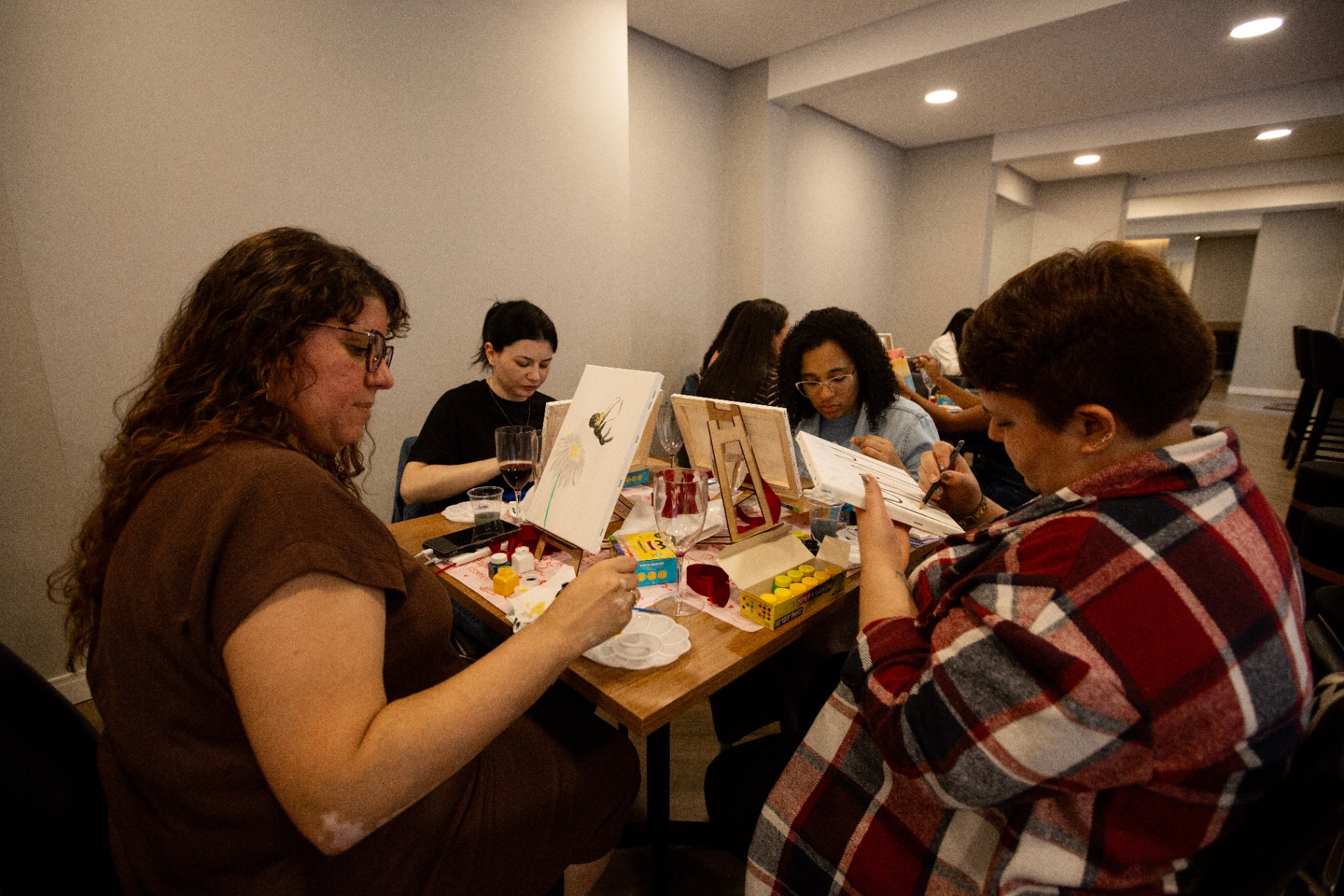 Grupo de mulheres pintando juntas em volta da mesa