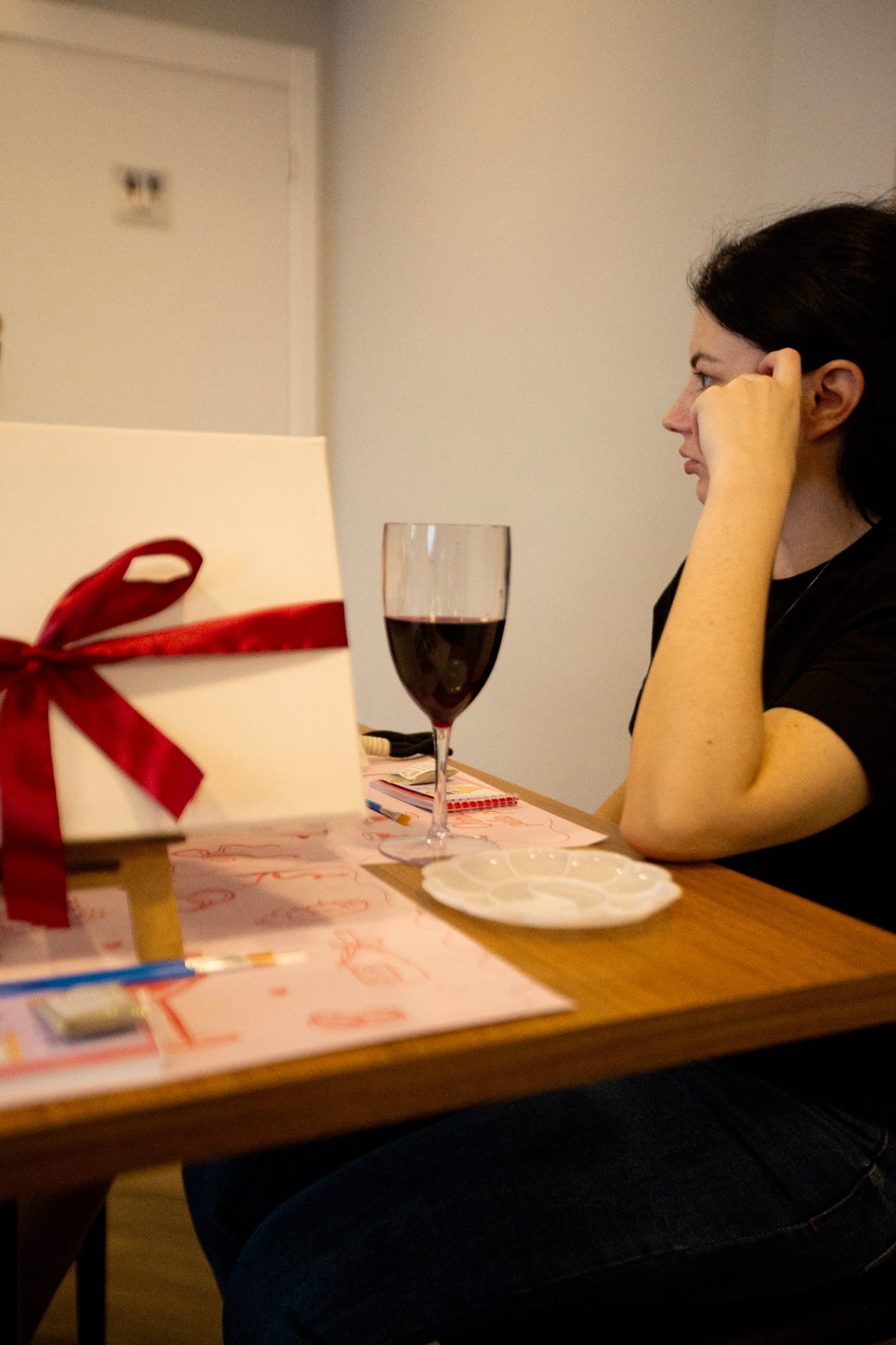 Detalhe da tela em branco com fita vermelha e taça de vinho