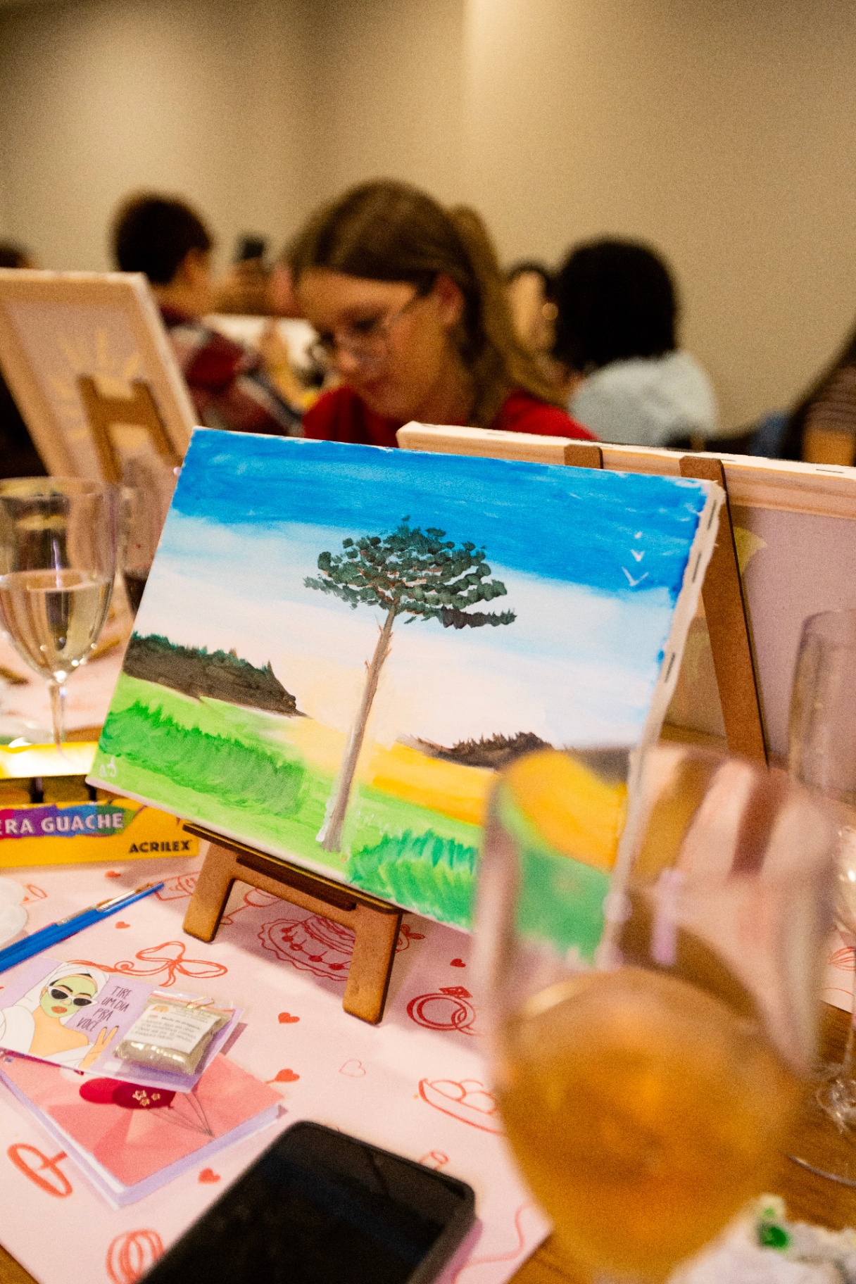 Tela pintada com paisagem sobre cavalete na mesa